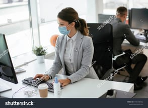 stock-photo-beautiful-businesswoman-with-medical-mask-working-in-office-covid-concept-1742168762