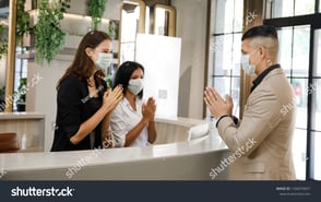 stock-photo-hotel-guest-and-receptionist-wearing-mask-to-protect-from-conronavirus-covid-having-new-practice-1706079697